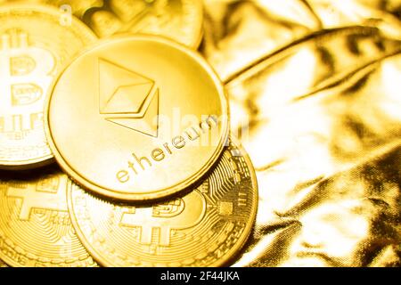 Gold ethereum coins on a golden background. Trading on the cryptocurrency exchange. Cryptocurrency Stock Market Concept. Virtual money concept. Mining Stock Photo