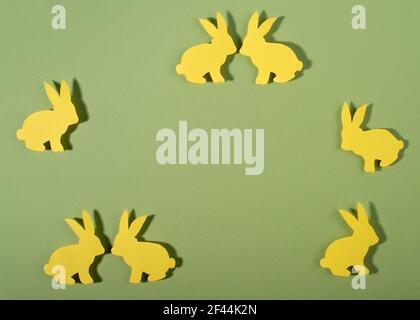 Happy Easter concept. Frame of yellow bunny on green background. Flat lay, top view. Copy space. Stock Photo