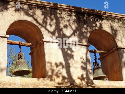 A closeup shot of an old rusted mission bells handing on wooden rods Stock Photo