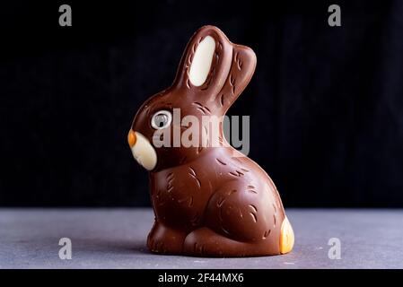 cute chocolate easter bunny on black dark background with soft natural light Stock Photo