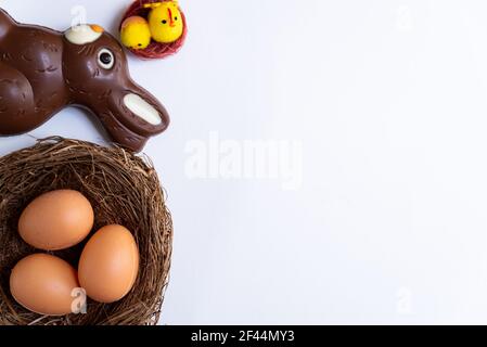 top view of easter eggs and chocolate bunny inside nest with birds on white background. isolated concept of easter with copy space Stock Photo