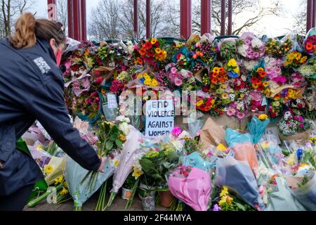 London, UK. 13th March, 2021. A sign that reads “End Violence Against Women” sits sorrounded by flowers. People attend a Vigil in memory of Sarah Ever
