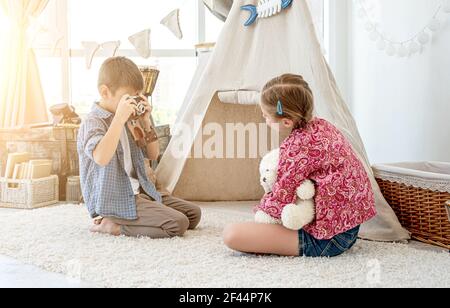 Little boy taking pictures of little girl Stock Photo