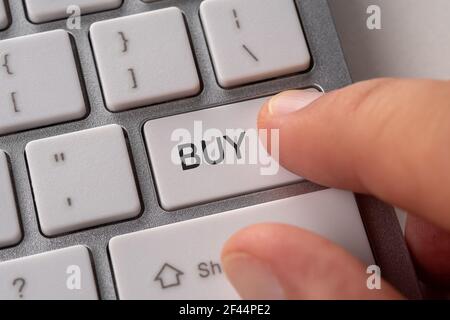 Male hand pressing keyboard button BUY. Shopping online concept. Stock Photo