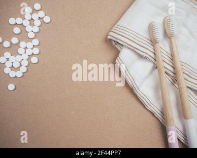 Bamboo toothbrush and dental tabs on a wooden background as a plastic free swap. Zero waste personal care products. Stock Photo