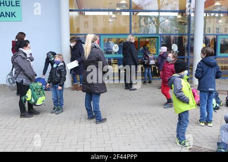 Halberstadt, Germany. 19th Mar, 2021. Pupils stand with their parents in front of the test centre in the Anne-Frank primary school in Halberstadt and wait for a free Corona rapid test. In Halberstadt, free rapid tests were started at 5 schools. A total of 30 students have volunteered to be tested. From Monday onwards, rapid tests will be carried out in all schools in Saxony-Anhalt. Credit: Matthias Bein/dpa-Zentralbild/dpa/Alamy Live News