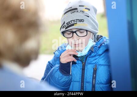 Halberstadt, Germany. 19th Mar, 2021. A pupil takes an anterior nasal swab in front of the test centre at the Anne-Frank primary school in Halberstadt. In Halberstadt, free rapid tests were started at 5 schools. A total of 30 pupils have volunteered to be tested. From Monday onwards, rapid tests are to be carried out in all schools in Saxony-Anhalt. Credit: Matthias Bein/dpa-Zentralbild/dpa/Alamy Live News