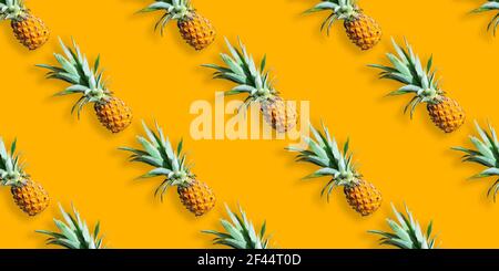 Seamless pattern of ripe pineapples isolated on orange background. Summer exotic fruit Stock Photo
