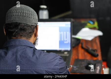 A back view of a man working on his laptop Stock Photo