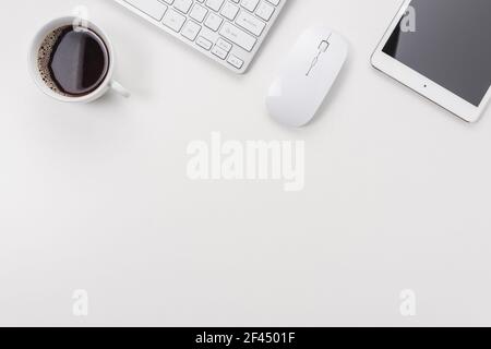 Workspace with computer keyboard, office supplies, and tablet on white background. Top view with copy space. Stock Photo