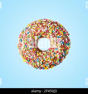 Donut with sweet color decoration on bright background. Minimal food concept. Stock Photo