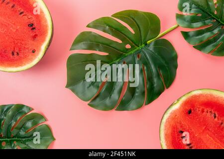 Watermelon with palm tree leaf on pink background. Creative minimal summer concept. Stock Photo