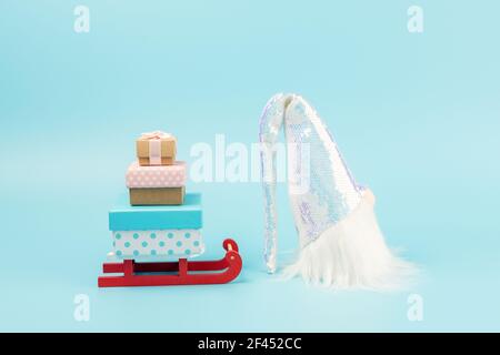 Santa claus sleigh with gift boxes and Santa Claus on blue background. Minimal New Year concept. Stock Photo