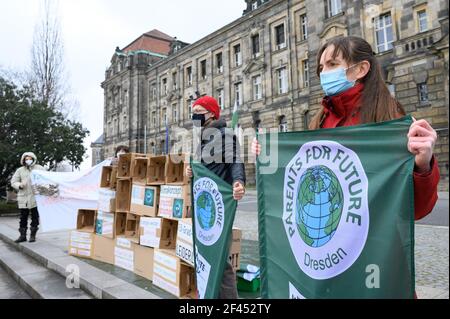 Dresden, Germany. 19th Mar, 2021. Activists from Fridays for Future stand in front of the Saxon State Chancellery next to an installation made of empty cardboard boxes. On March 19, 2021, climate activists in more than 200 German cities began their protest actions against current climate policies. Credit: Sebastian Kahnert/dpa-Zentralbild/dpa/Alamy Live News Stock Photo