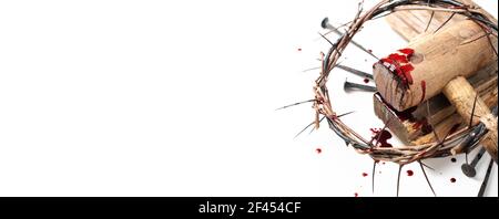 Old wooden cross, hammer, bloody nails and crown of thorns isolated on white background. Copy space. Good friday. Passion, crucifixion of Jesus Christ Stock Photo