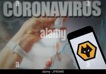 File photo dated 09-01-2021 of The Wolverhampton Wanderers Football Club logo seen displayed on a mobile phone with a Coronavirus illustration on a monitor in the background. Issue date: Friday March 19, 2021. Stock Photo