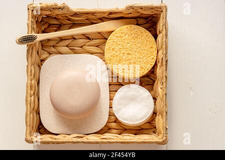 home spa accessories - water hyacinth box with sponges, soap bars on wooden background Stock Photo