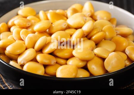 Salted yellow lupine beans close-up in a bowl on the table. horizontal Stock Photo