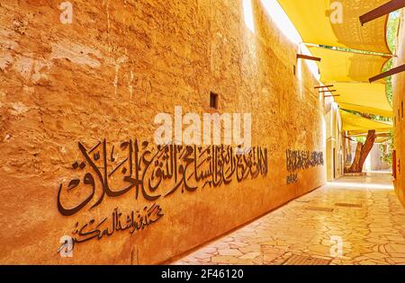 Walk the old scenic street of Al Fahidi, with tall adobe walls, covered with Arabic calligraphy, Dubai, UAE Stock Photo