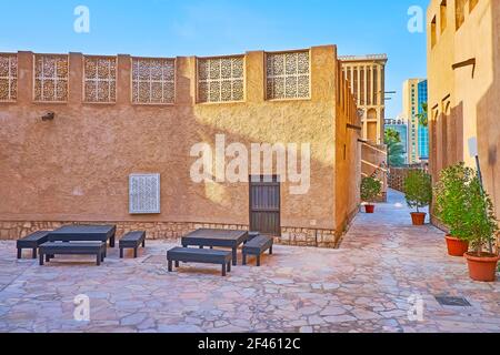 The benches in shady street in front of the scenic mansion, decorated with carved adobe panels, Al Fahidi, Dubai, UAE Stock Photo