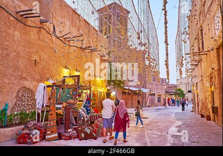 The scenic street of Al Fahidi, decorated with lighting garlands and colorful carpets of local store, Dubai, UAE Stock Photo