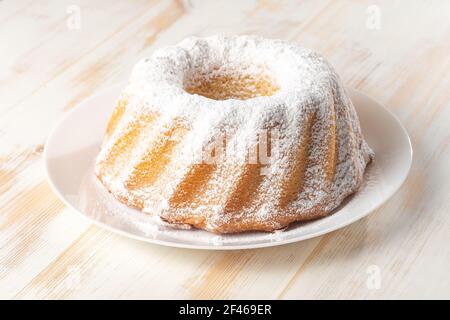 Homemade vanilla bundt cake on white wooden background. Stock Photo