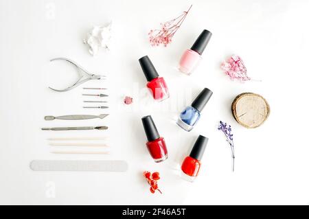 Tools of a manicure set on a white background. Bottles different bottles of nail polish and tools around. Stock Photo
