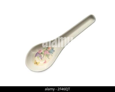 White spoon with a pattern of flowers on white background. Clipping path Stock Photo