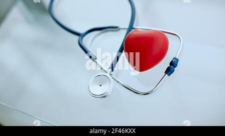 phonendoscope and red heart on the table. Stock Photo