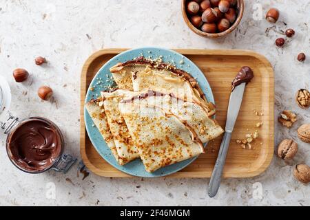 Homemade crepes, tasty thin pancakes with chocolate and nuts. Stock Photo