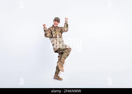 Full size portrait of astonished positive lady fists knee up open mouth scream yeah isolated on white color background Stock Photo