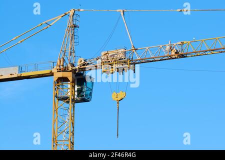 yellow heavy duty high crane head on blue sky background Stock Photo