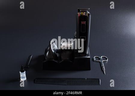 Set of shaving machine with attachments and other tools for barber on a black background. Stock Photo