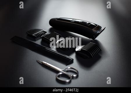 Black wireless shaving machine with attachments, close up, on black background. Stock Photo