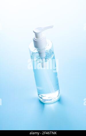 Coronavirus prevention hand sanitizer gel in bottle. Hand disinfectant gel on blue table. Stock Photo