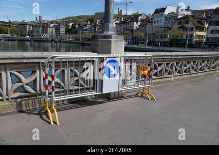 Steel barrier fence with traffic sign obstacle right turn around sign, yellow warning lights hanging on the fence, by day, without people Stock Photo