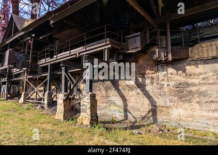 Abandoned industrial site, concrete and brick wall, outriggers of steel I-beams, rusting metal, horizontal aspect Stock Photo