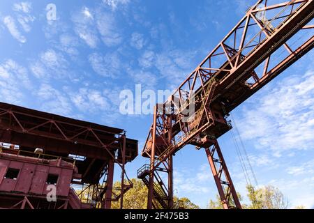 Monumental industrial architecture, metal construction on a derelict manufacturing site, bright blue sky, horizontal aspect Stock Photo