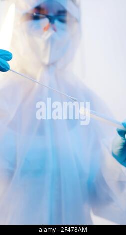 Nurse in full protective suit performing nasal swab covid-19 test. High quality photo Stock Photo