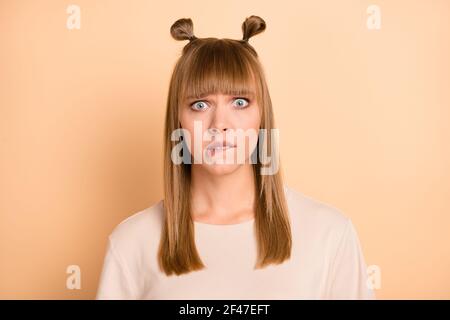 Photo portrait of nervous guilty girl biting lips made mistake staring isolated on pastel beige color background Stock Photo