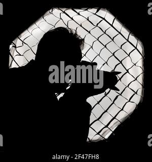 Silhouette of a photographer against a large light softbox with honeycomb grid, typical of a photo studio Stock Photo