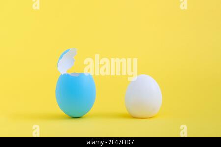 A boiled egg and a blue eggshell isolated on a yellow background Stock Photo