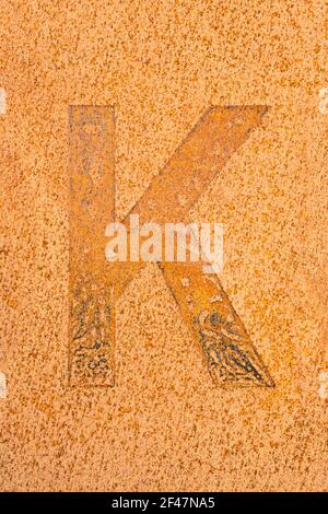 Remains of a letter K on a rusted metal plate Stock Photo