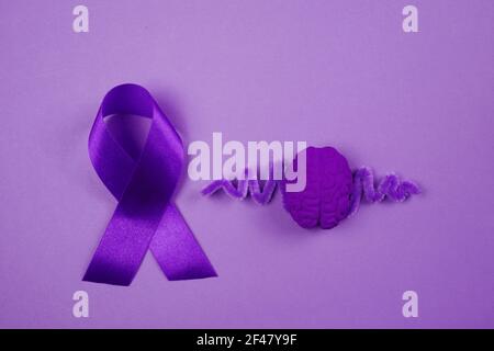 Purple day. World epilepsy day. Purple ribbon and brain on purple background