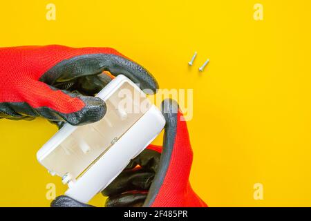 Electrician peeling off insulation from wires - closeup on hands and pliers Stock Photo