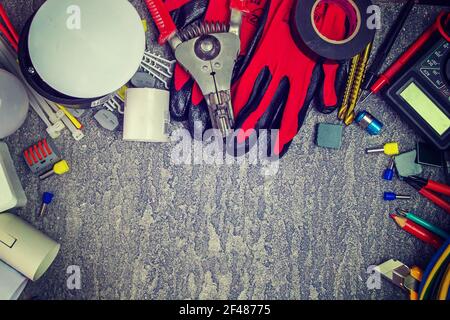 Electrical tools and a set of components for use in electrical installations on a gray background with a place for text Stock Photo