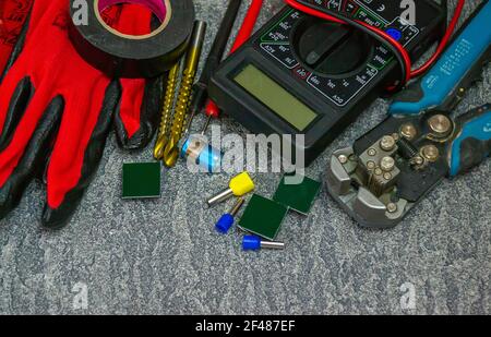 Electrical tools and a set of components for use in electrical installations on a gray background with a place for text Stock Photo