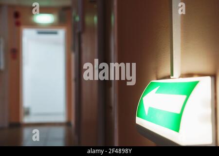 Evacuation arrow with illumination from the building to the room, guiding to the exit. Evacuation in case of fire and cataclysm Stock Photo