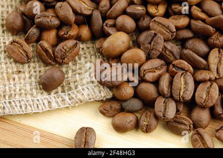 Coffee beans on sacking bag on desk. Stock Photo
