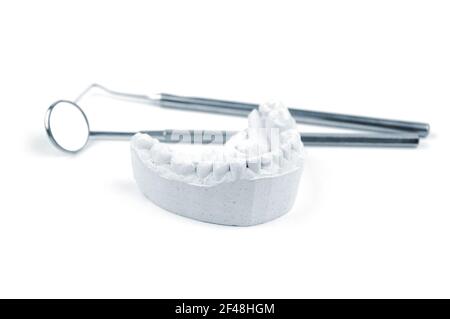Gypsum dental impression and dental tools on a white background. Selective focus. Stock Photo